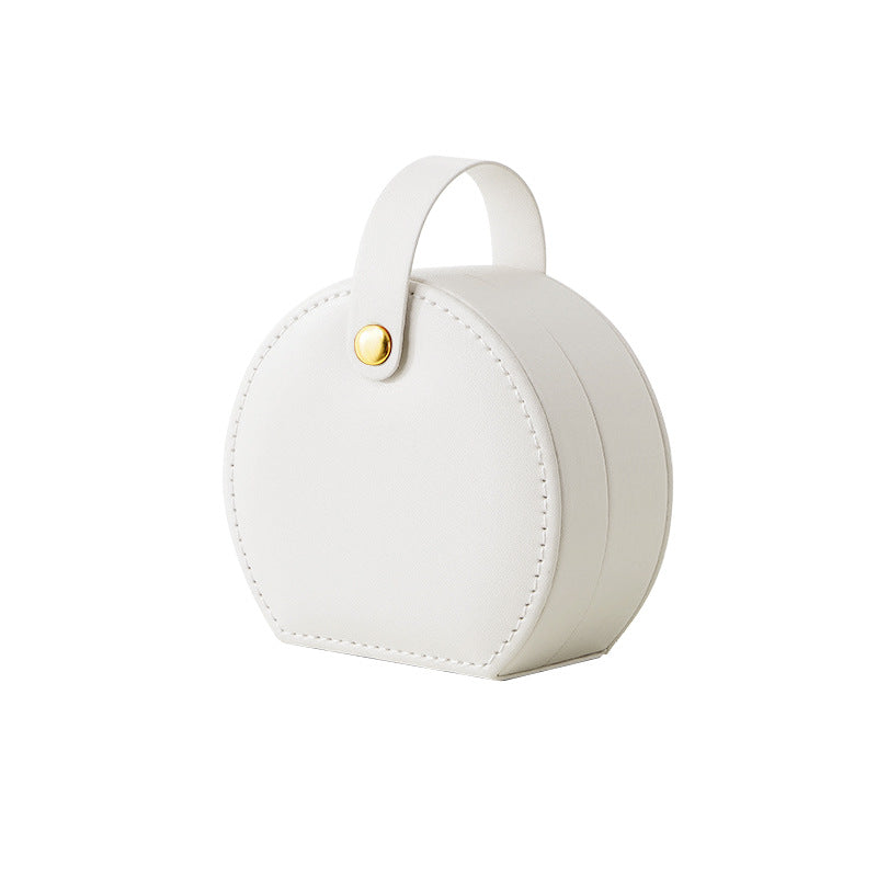 White round travel jewelry case with a carry strap