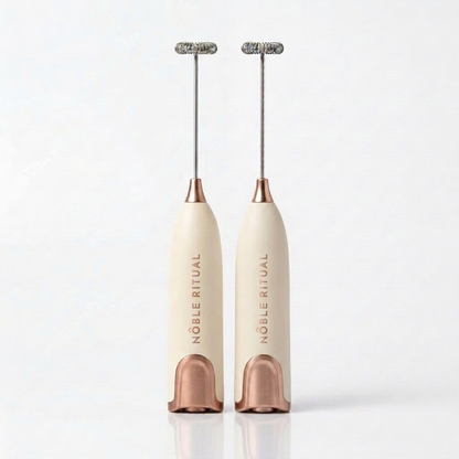 Noble Frothé Set of 2 in Two Cream: two cream frothers with rose-gold collars and bases, vertical rose-gold NÔBLE RITUAL wordmarks and coiled steel whisks