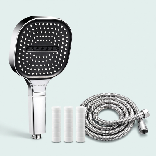 Clearpour filtered showerhead set: square-plate head, hose and three filter elements on a pale green background