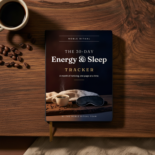 The 30-Day Energy & Sleep Tracker as a printed book on a walnut table beside a cup of coffee